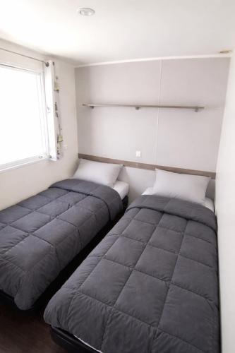 two beds sitting next to each other in a room at Kabana Village in Saint-Hilaire-de-Riez