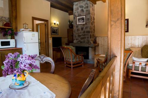 una cucina e un soggiorno con tavolo e camino di Casa Rural Valdeascas a Navarredonda de Gredos