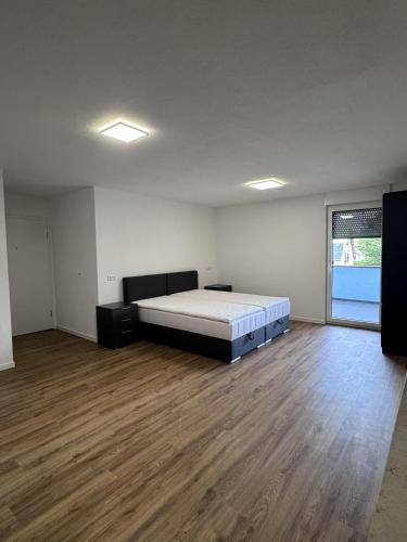 a large bedroom with a bed and a wooden floor at Bayman Apartments in Ellhofen