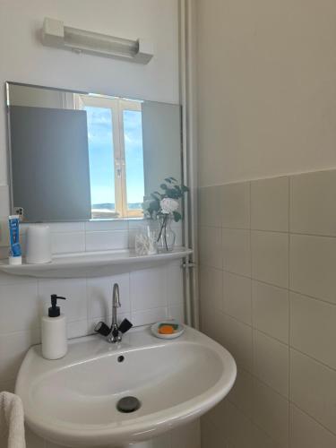 a white bathroom with a sink and a mirror at Bastide en Margeride in Châteauneuf-de-Randon