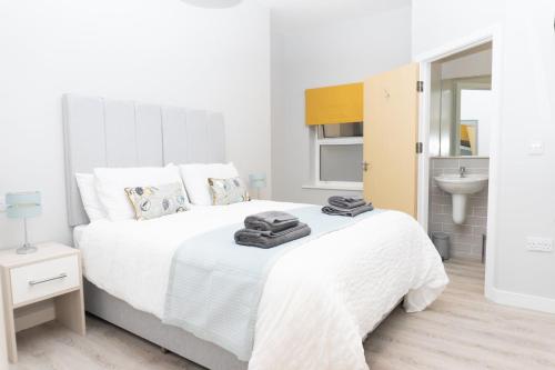 a white bedroom with a white bed and a sink at Spa Court in Cheltenham