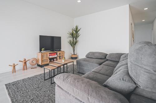 a living room with a couch and a flat screen tv at Villa Delfina with private pool in Mariquiteira