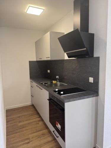 a kitchen with a black counter top and a sink at Bayman Apartments in Ellhofen
