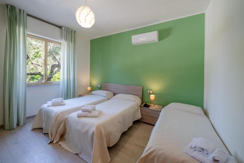 two beds in a room with green walls at hotel La pineta in Marina di Carrara