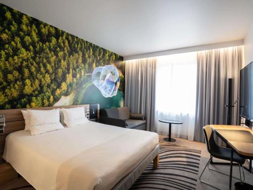 a hotel room with a bed and a flower mural at Novotel Vilnius Centre in Vilnius