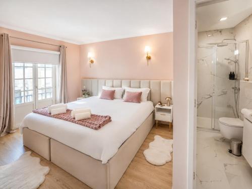 ein Schlafzimmer mit einem großen weißen Bett und ein Badezimmer in der Unterkunft Opus House in Guimarães