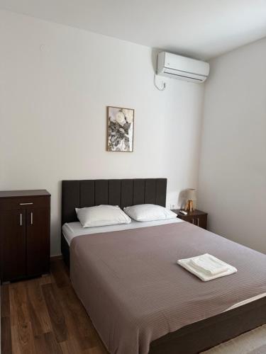 a bedroom with a bed with two white towels on it at Panorama View Holiday Home in Šušanj