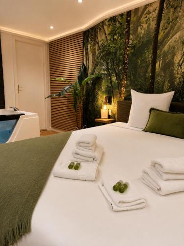 a bedroom with a white bed with towels on it at Spa et sauna - Loft Cataleya in Belfort