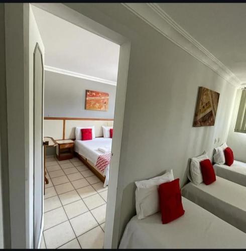 a bedroom with two beds and a room with a hallway at Hotel Teofilo Otoni in Teófilo Otoni