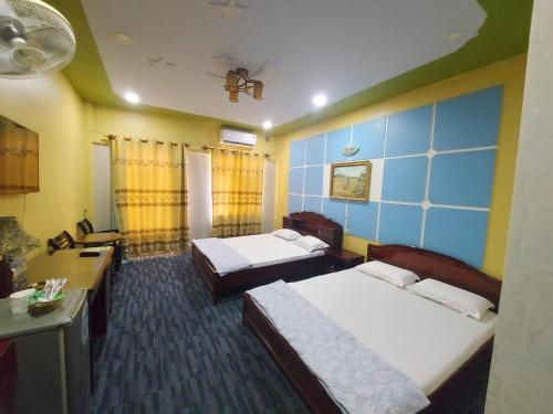 a hotel room with two beds and a blue wall at Tan Tay Do Hotel in Can Tho