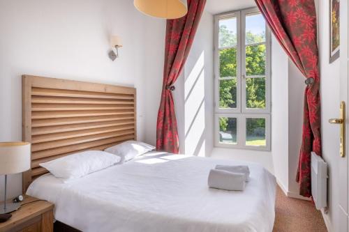 a bedroom with a large white bed and a window at Résidence Odalys Le Château de Kéravéon in Erdeven