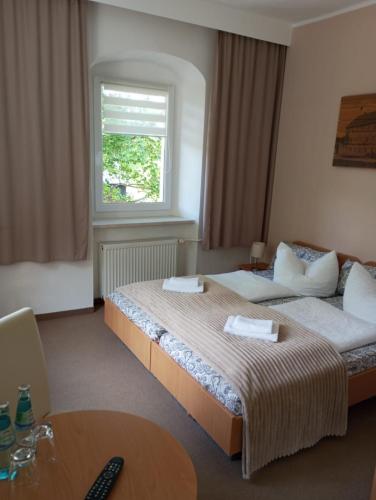a hotel room with two beds and a window at Übernachten im 500 Jahre alten ehemaligen Pochwerk im Erzgebirge - Pension ,,Sommerfrische'' in Ehrenfriedersdorf