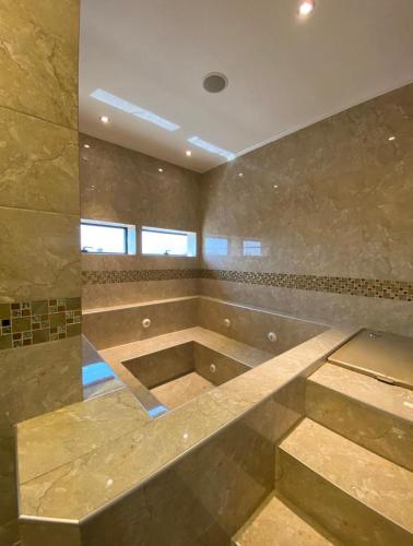 a large bathroom with a large shower with a bench at Hotel Sun in Encarnación