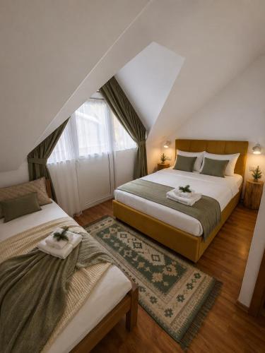 a bedroom with two beds and a window at POARTA PADINA, statiunea Pestera-Padina, Bucegi in Moroeni