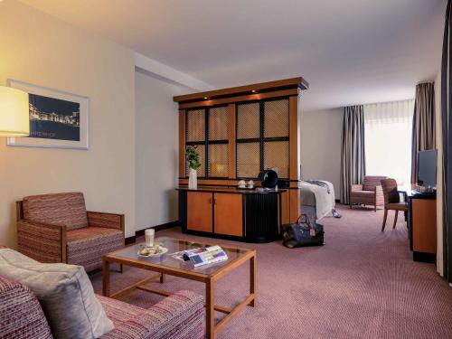 ein Wohnzimmer mit Sofa und Tisch in der Unterkunft Mercure Hotel Düsseldorf City Center in Düsseldorf