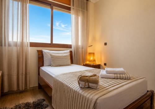 a bedroom with a bed with a large window at Elegant & Bright Flat in the Heart of Tangier in Tangier