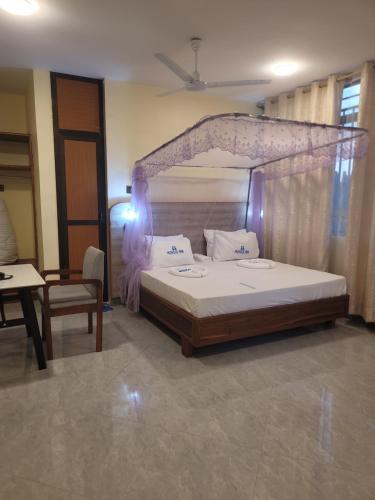 a bedroom with a bed with a canopy at Moveck Inn in Dar es Salaam