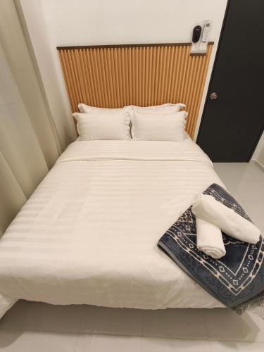a bed with white sheets and white towels on it at The Kobe House 2 in Kuala Berang