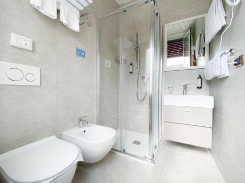 a bathroom with a shower and a toilet and a sink at Hotel Vela D'oro ***S in Bardolino