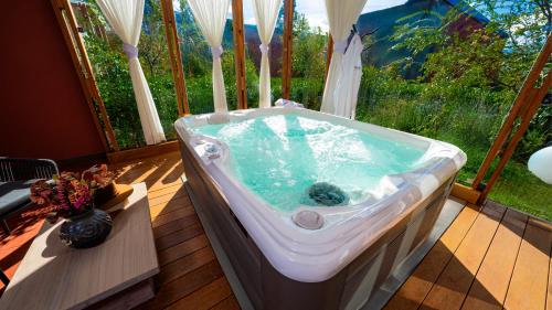 a bath tub in a room with a window at Viscas Hotel Luxury Resort & Spa in Pariahuanca