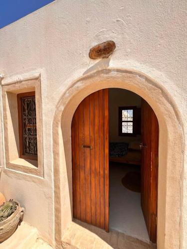 an entrance to a building with a wooden door at Dar Hallouma - WostelDjerba community in Djerba