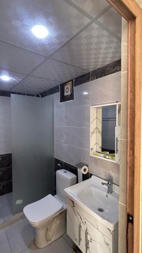 a bathroom with a white toilet and a sink at Desert Hello Camp in Wadi Rum