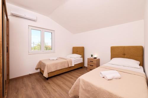 a bedroom with two beds and a window at OLEA Holiday Home Benkovac-private pool,garden and parking in Šopot