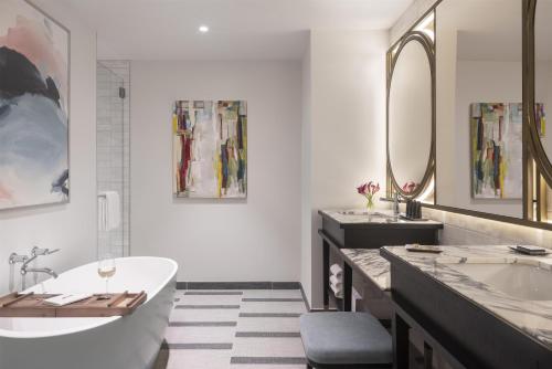 a bathroom with two sinks and a tub and a mirror at Hyatt Centric Downtown Nashville in Nashville