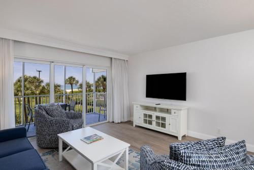 a living room with a tv and a couch and chairs at Beach Villa 2323 - Captiva One Bedroom Deluxe Beachfront Residence in Captiva