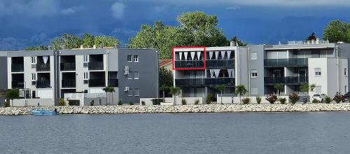 two apartment buildings next to a body of water at APARTMAN SUNSIDE2 NIN in Nin