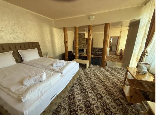 a bedroom with a large bed and a table at Guest House Скиора in Chepelare