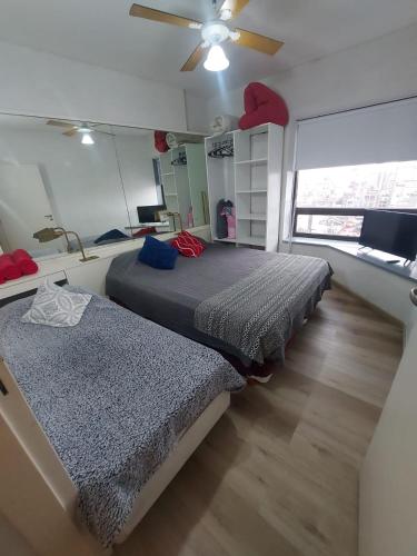 a bedroom with two beds and a ceiling fan at Torre Obelisco - Apart 2 Amb en Av Corrientes, Buenos Aires, Argentina in Buenos Aires