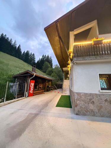 a building with a porch and a building with a roof at Guest House Скиора in Chepelare