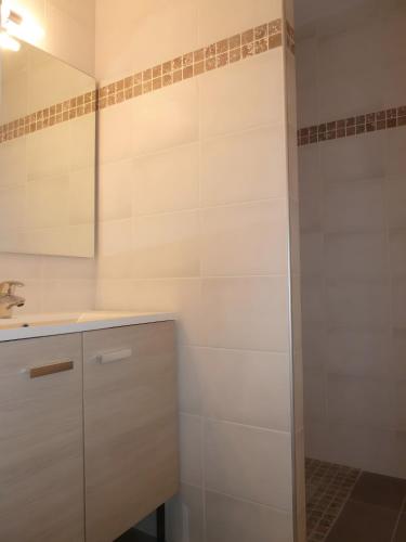 a white bathroom with a sink and a mirror at La Roseraie des Côtes - Piscine in Vinsobres