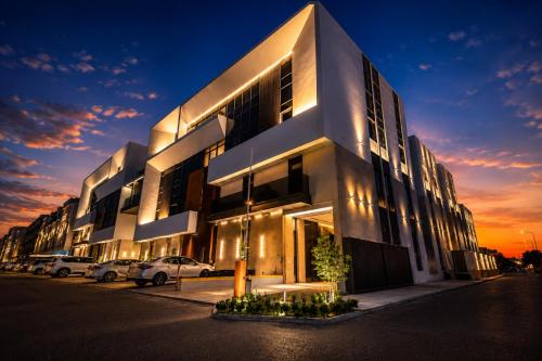 a large building with cars parked in front of it at Liora Al Yasmin District in Riyadh