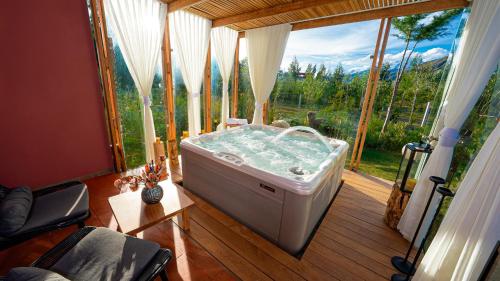 a hot tub in a room with a large window at Viscas Hotel Luxury Resort & Spa in Pariahuanca