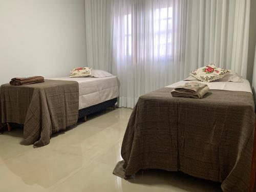 two beds in a room with a window at Casa 161 in Diamantina