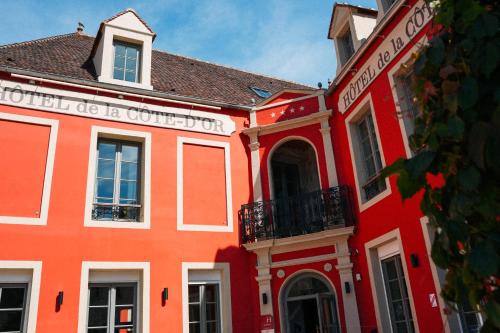 a large red building with a white trim at Hotel Relais De La Cote D'or in Semur-en-Auxois
