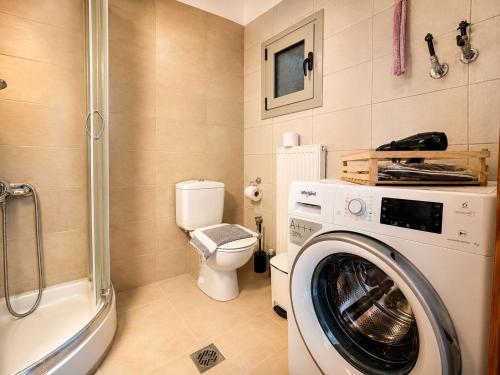 a bathroom with a washing machine and a toilet at MK Seaview Stays in Neos Marmaras