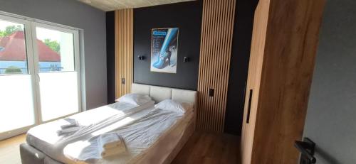 a bedroom with a white bed with a window at Apartament Baltic 13 Mielno in Mielno