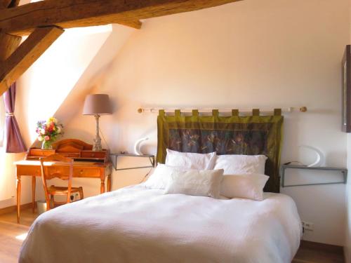 a bedroom with a large white bed with a desk at Chambres d'Hôtes L’Échappée Belle in Saint-Brisson-sur-Loire