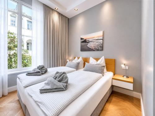 two beds in a room with two windows at Ferienwohnung Luxus Sonnensuite in der Strandvilla Charlotte Binz in Binz