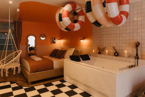 a bedroom with a tub and a bed and a tub at La Pimenta - SPA privatif & expérience immersive in Dole