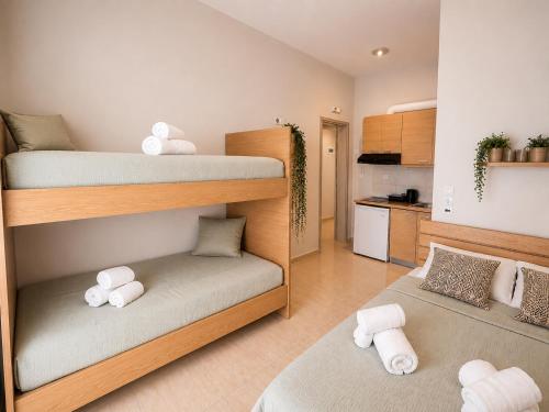 a small room with two bunk beds and a kitchen at Aurora Apartments Stavros in Stavros