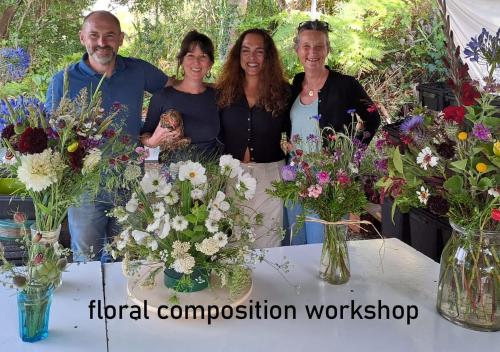 a group of people standing around a table with flowers at Myhomereservation Flores Daqui Lodge Colares Sintra in Colares