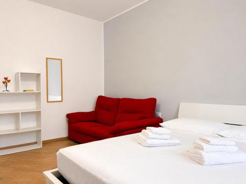 a bedroom with a red chair and a bed at Da Nonno Eddie - tranquillo bilocale - wi-fi - tv - parcheggio vicino in Trieste
