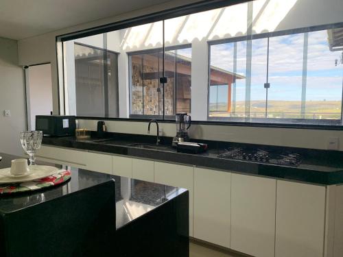 a kitchen with a sink and a large window at Casa 161 in Diamantina