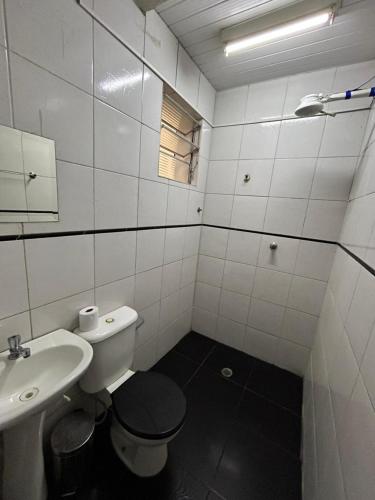 a white bathroom with a toilet and a sink at Casarão da Sé in São Paulo