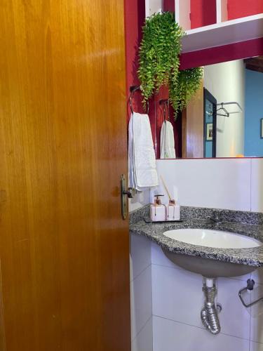 a bathroom with a sink and a mirror at Hostel Recanto Verde - Conforto e Tranquilidade em Campo Grande in Campo Grande