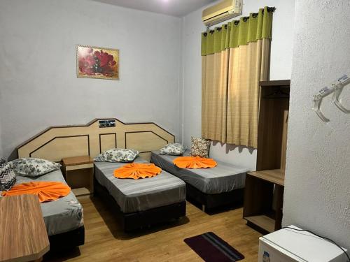 a room with two beds with orange pillows at Casarão da Sé in São Paulo